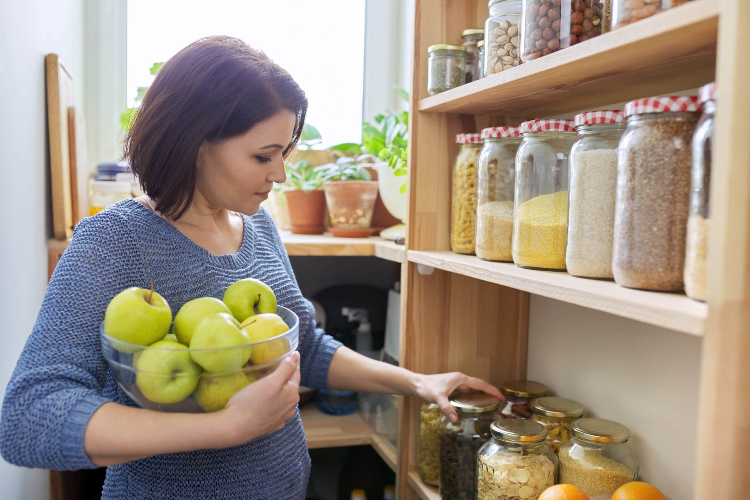 Woman,With,Bowl,Of,Green,Apples,In,Pantry,,Organizing,In